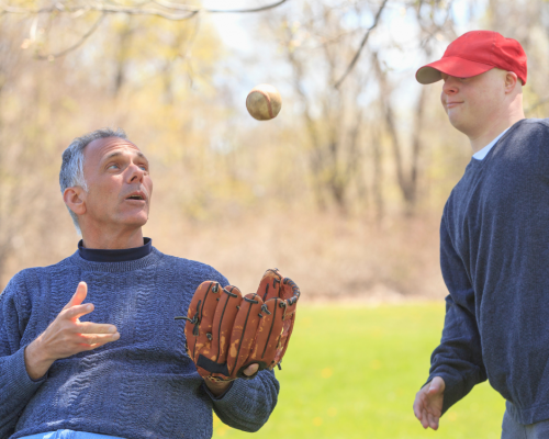 Aging with a Spinal Cord Injury A man with a spinal cord injury plays ball with his son.
