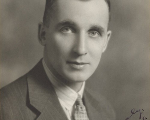 An old photograph of a young Dr. Harry Botterell in suit and tie shot from the chest up.