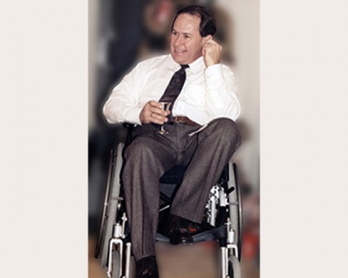 Kirby Rowe, smiling, seated with a drink in his hand