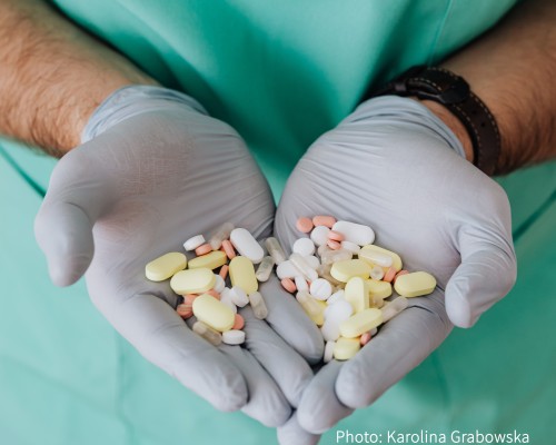 A doctor holding multiple kinds of pills.