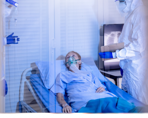 Person lying in hospital bed with respirator unable to talk to doctors