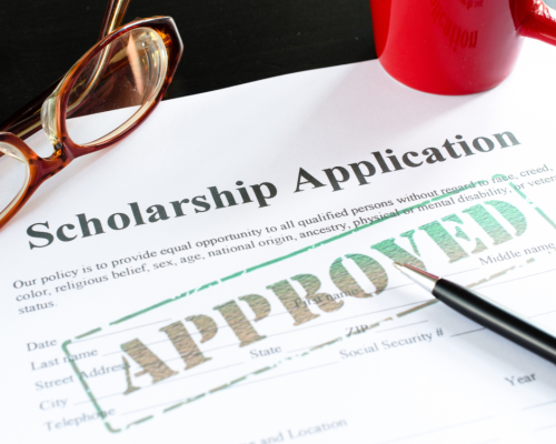 close up of a scholarship application with the word approved across the paper.