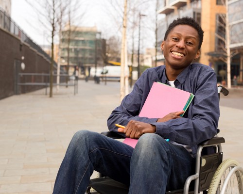 Student sitting in his wheelchair in the middle of campus